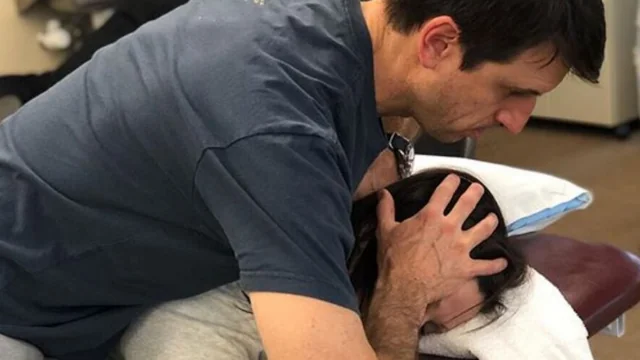 PTC Therapist performs neck adjustment on patient.